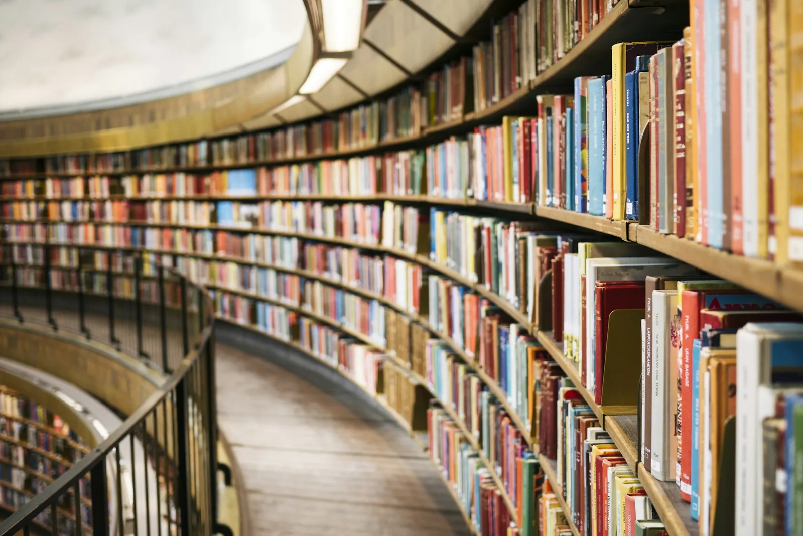 Curved shelves of books receding along a library balcony