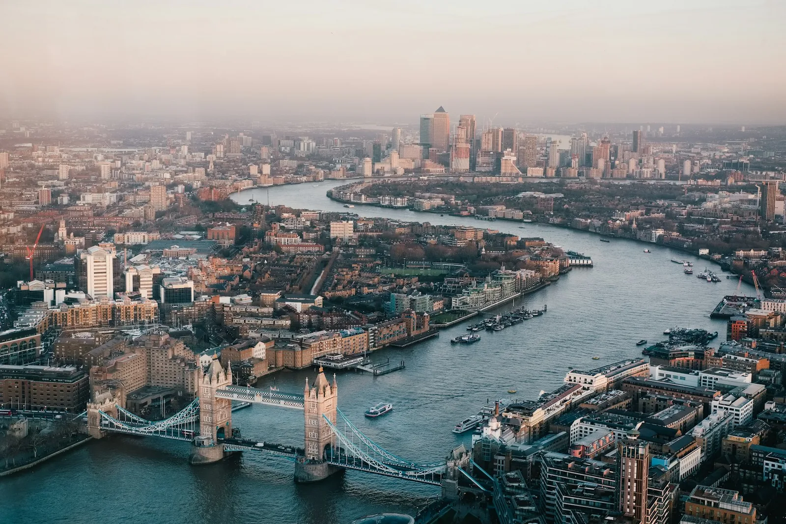Aerial view of London at dusk showing Tower Bridge, the Thames and Canary Wharf
